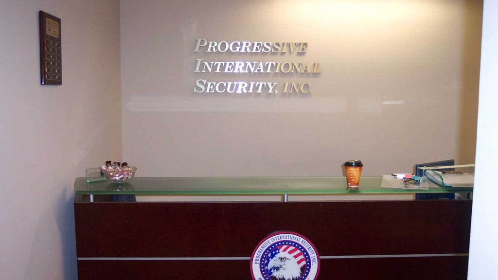SECURITY COMPANY - PROGRESSIVE INTL. SECURITY - CORPORATE IDENTITY - DIMENSIONAL LETTERS - RECEPTION AREA SIGN - LOBBY SIGN - BRUSHED ALUMINUM- INTERIOR SIGN