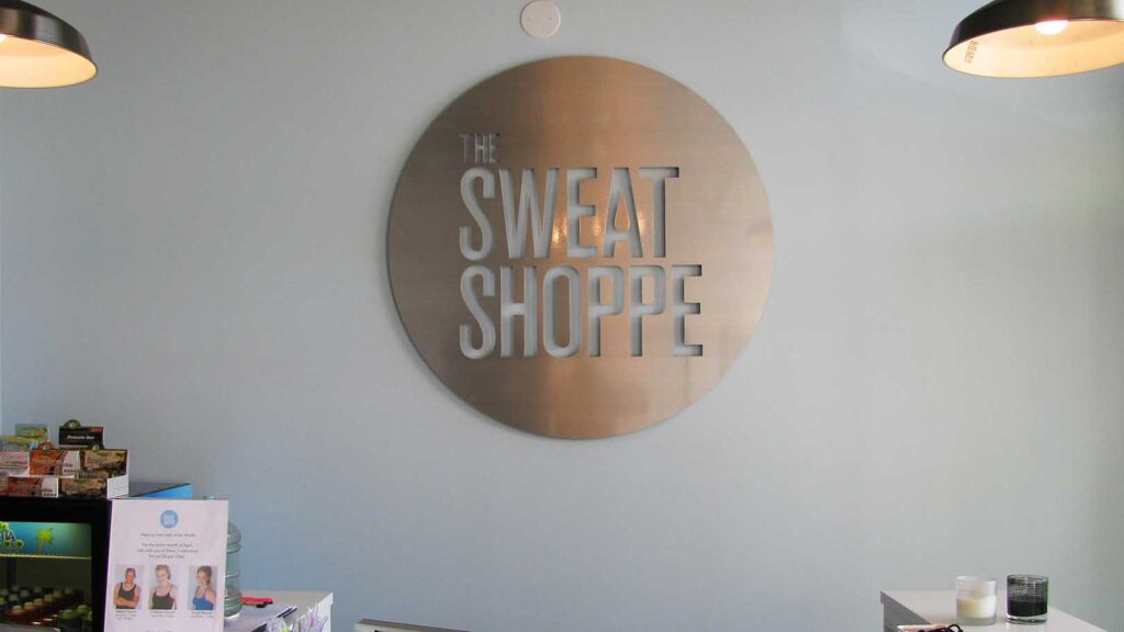 WELLNESS CENTER - THE SWEAT SHOPPE - CORPORATE IDENTITY - RECEPTION AREA SIGN - LOBBY SIGN - INTERIOR SIGN - BRUSHED ALUMINUM