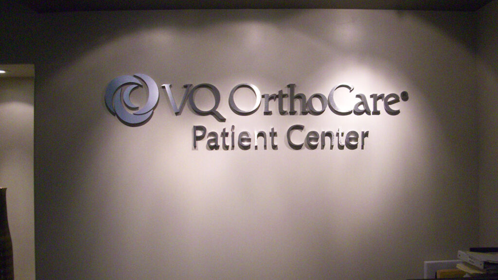 MEDICAL OFFICE - VQ ORTHO CARE PATIENT CENTER - CORPORATE IDENTITY - DIMENSIONAL LETTERS - RECEPTION AREA SIGN - LOBBY SIGN - BRUSHED ALUMINUM - INTERIOR SIGN